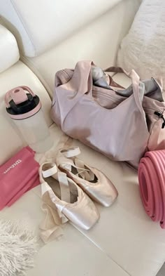 there are many items that can be found on the couch, including ballet shoes and a water bottle