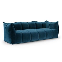 a green velvet sofa with three pillows on it's back and one arm facing the camera