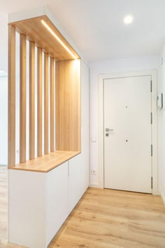 an empty room with wooden stairs and white walls, along with hardwood flooring on both sides