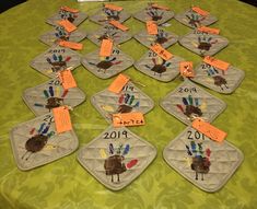 a table topped with lots of place mats covered in handprinted turkeys and numbers