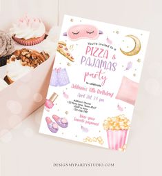 a pink box filled with lots of cupcakes and other treats next to a card