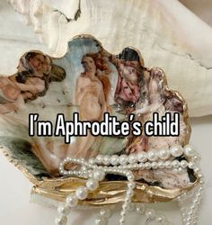 a shell with pearls on it that says i'm aphrodite's child