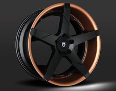 a black and copper wheel on a dark background