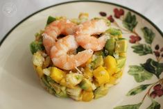 a plate with shrimp, corn and avocado on it