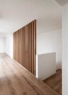 an empty room with wood slats on the wall and wooden flooring in it