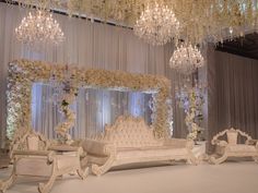 an elaborately decorated stage set with chandeliers and flowers on the ceiling,