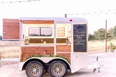 the food truck is decorated with greenery and chalkboard writing on it's side