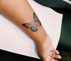 a woman's arm with a butterfly tattoo on the left side of her body