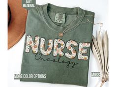 a green shirt with the words nurse on it next to some feathers and a hat