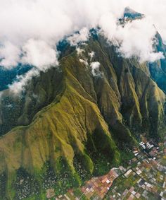 an aerial view of the mountains and valleys in hawaii, looking down on town below