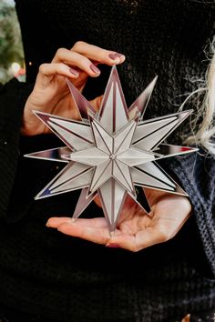 a woman holding an origami star in her hands