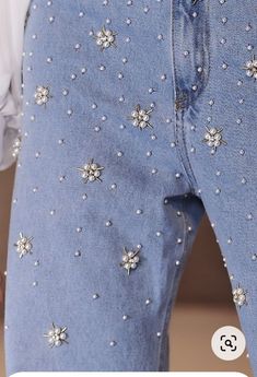 a person wearing blue jeans with silver stars on them