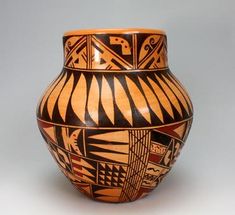 a brown and black vase sitting on top of a table