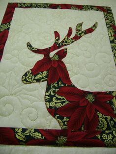 a quilted deer with red flowers on it