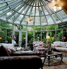 a sun room with couches, chairs and tables