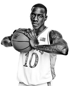 a black and white photo of a basketball player with tattoos on his arm holding a ball