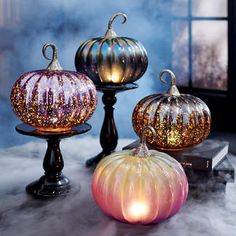 three glass pumpkins sitting on top of a table