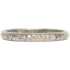 an antique wedding band with skulls on the side and diamonds in the middle, set in 18k white gold