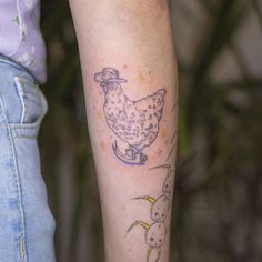 a tattoo on the arm of a woman with a chicken and dog in front of her