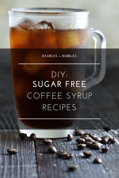 a cup filled with coffee and beans on top of a wooden table next to the words diy sugar free coffee syrup recipes