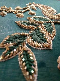 green and gold beaded fabric with leaves on it