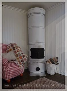 a white stove sitting in the corner of a room next to a chair and rug