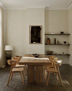 a dining room table and chairs in front of a window