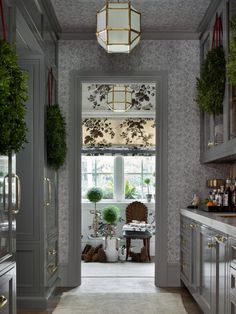 an open door leading to a kitchen with lots of counter space and decor on the walls