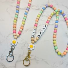 the beaded lanyard has two key chains attached to it, and is decorated with colorful beads