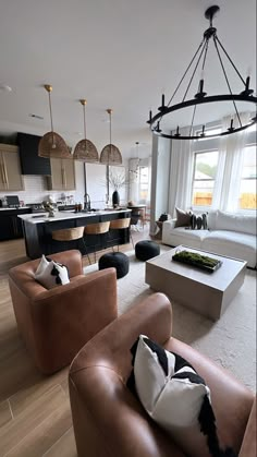 a living room filled with furniture next to a kitchen