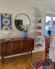 a dining room with a table, chairs and a large mirror on the wall above it