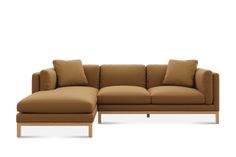 a brown sectional couch with pillows on the top and bottom, in front of a white background