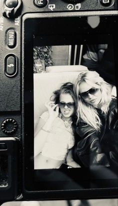 black and white photograph of two women in front of a camera