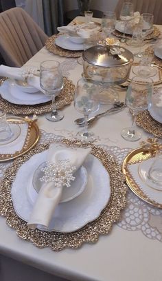 the table is set with white and gold dishes