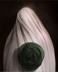 a ball of yarn sitting on top of a white cloth covered in dark green thread