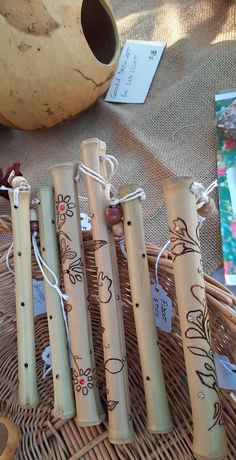 four bamboo flutes sitting on top of a wicker basket