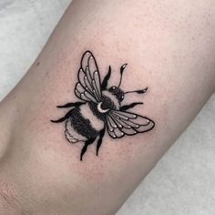 a small black and white bee tattoo on the right arm, it looks like he's getting ready to fly