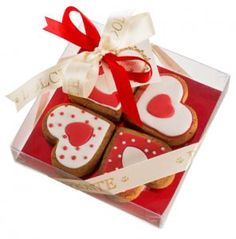 three heart shaped cookies in a clear box with ribbon and bow on the top that says i love you