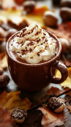 a cup filled with whipped cream surrounded by leaves