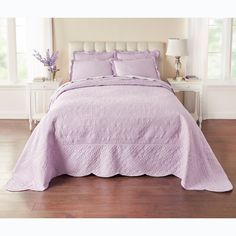 a bed with a purple bedspread and pillows