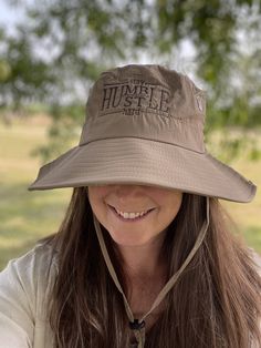 Bucket hat with decorative embroidery stitching and adjustable ties for one size fits all. Tan colored hat with two adjustable strings and embroidery.  This hat is made of waterproof material with snaps on the sides to fold up and an adjustable string to hold in place with a sliding clasp. Two machine embroidery options: One with a bee loving touch.  Or  Stay Humble Hustle Hard Handmade from a smoke free home in West Central Illinois. Adjustable Bucket Hat For Adventure, Adjustable Wide Brim Bucket Hat For Adventure, Bucket Hat With String, Humble Hustle, Stay Humble Hustle Hard, Boonie Hat, Decorative Embroidery, Safari Hat, Touch Love