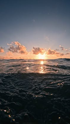 the sun is setting over the ocean as it reflects in the water's surface