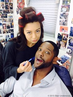 a man getting his hair cut by a woman