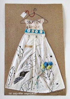 a dress made out of paper and buttons on a piece of cardboard with a ruler attached to it