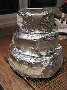 three pieces of tin foil stacked on top of each other in front of a window