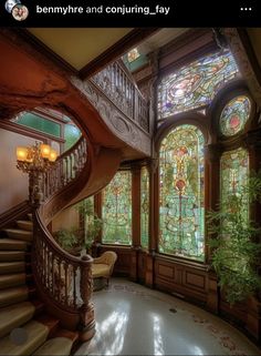 an ornate staircase with stained glass windows and potted plants