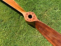 a wooden paddle sitting on top of green grass