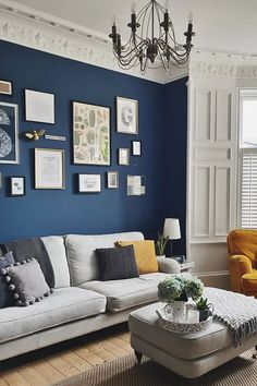 a living room with blue walls and pictures on the wall