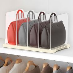 a row of purses hanging on a rack in a store or office space with wooden hangers