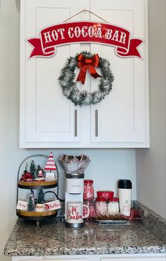 a hot cocoa bar with christmas decorations on the front and back cabinets, along with other holiday treats